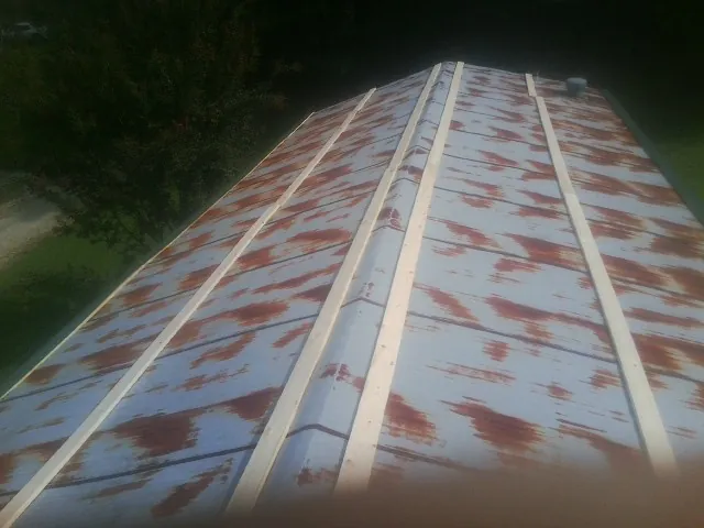Rusted metal roof panels with new wood purlins before replacement — Storm Damage Roof Repair in Schenevus by Roofing Brothers