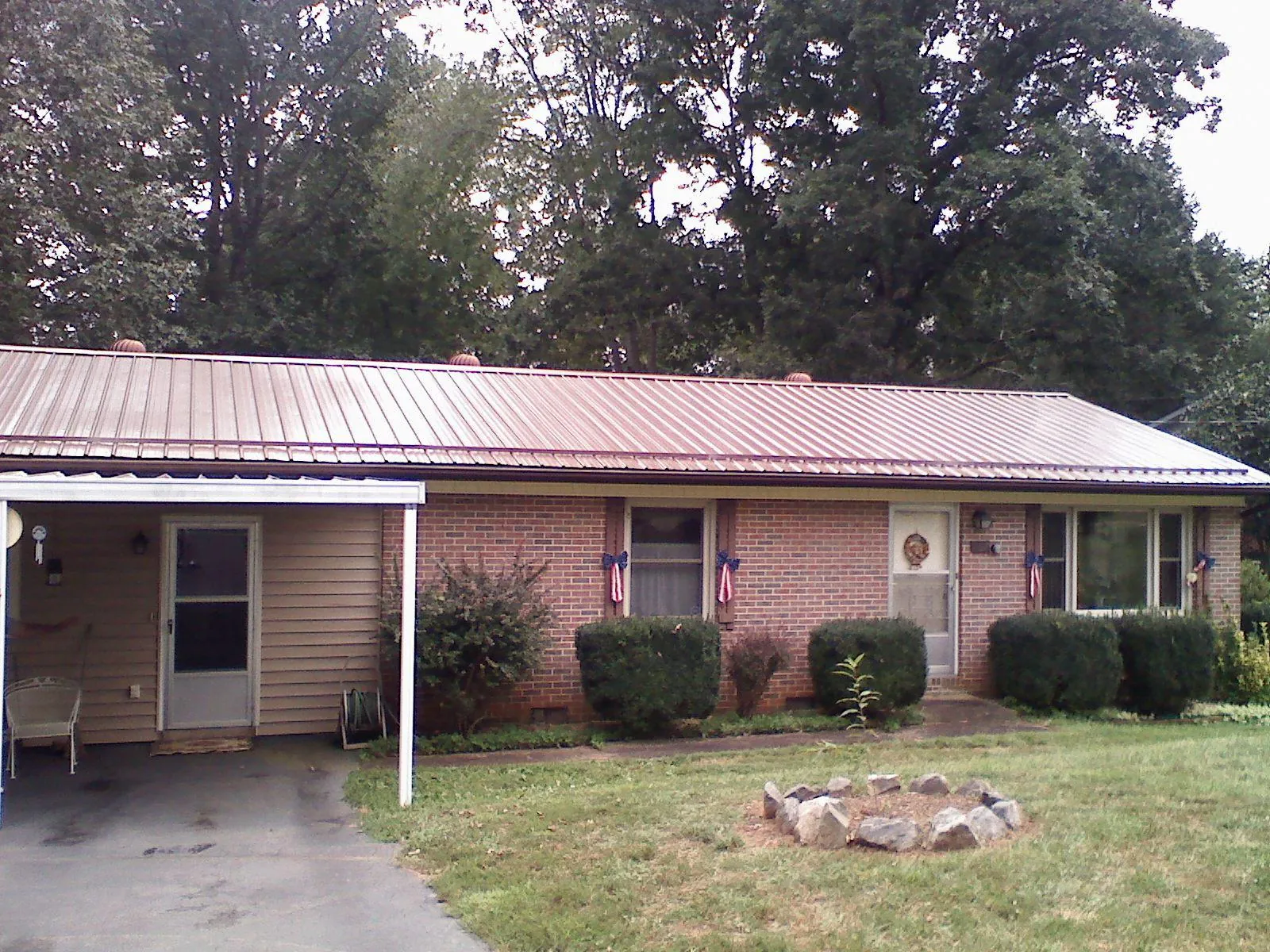 Bronze metal roof and carport on a brick ranch home — Roof Repair work by our crew in Schenevus